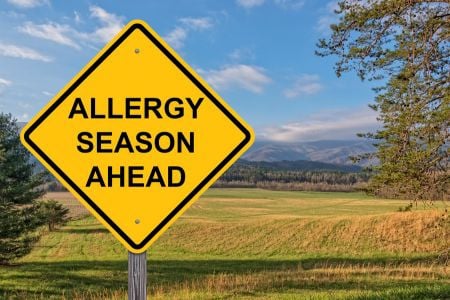 Yellow caution sign that says allergy season ahead