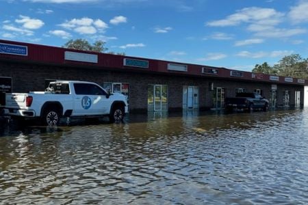 white truck parked in water in front of a business
